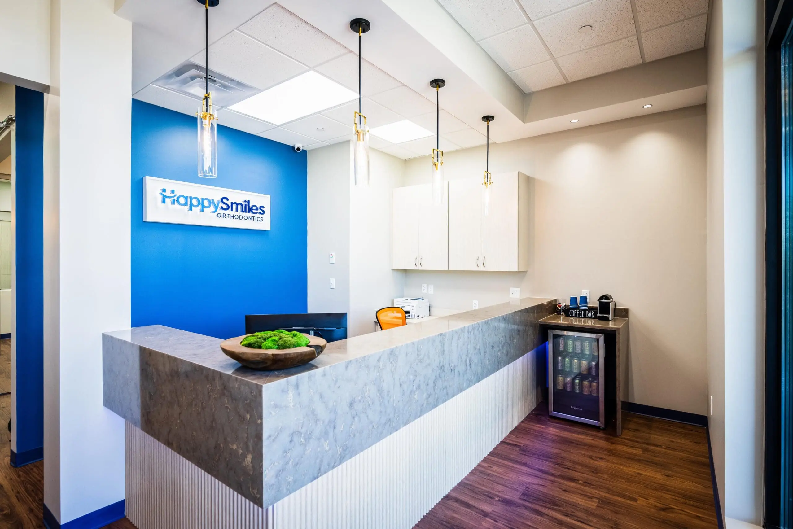 At Happy Smiles Orthodontics in St. Augustine, FL, the modern reception area features a marble counter, blue accent wall, and comfortable waiting amenities—offering comfort and confident smiles for every mouth breather.