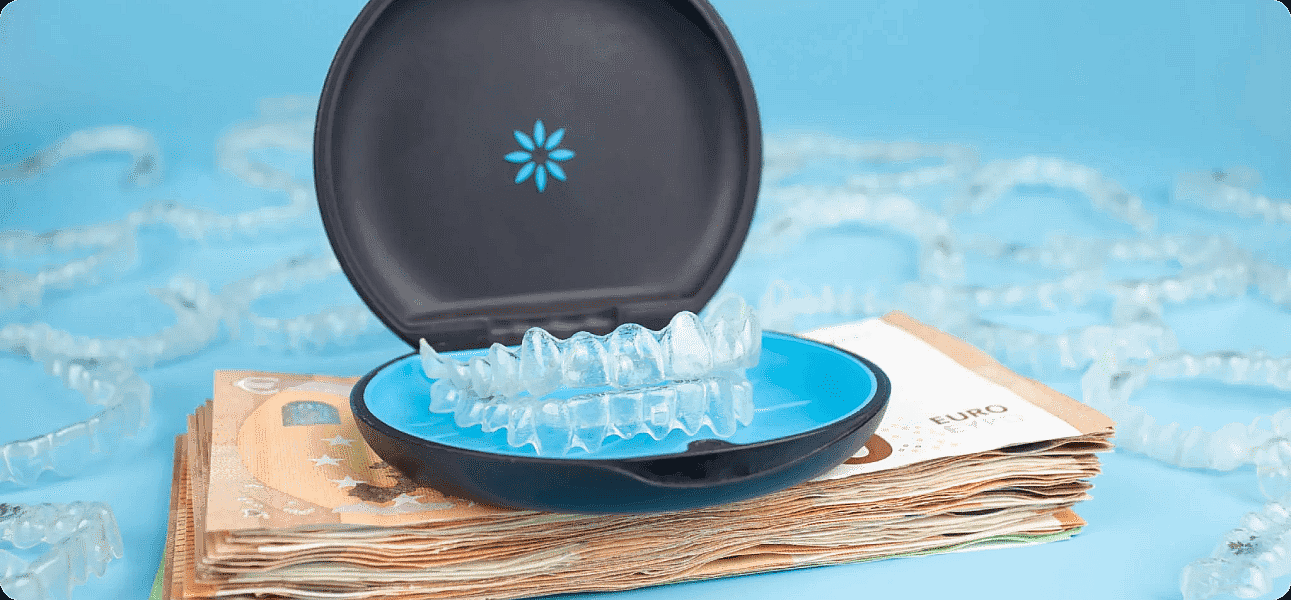 Featuring a stack of euro banknotes alongside a dental aligner case with clear aligners, this image from Happy Smiles Orthodontics in St. Augustine, FL highlights Invisalign cost, with additional aligners scattered on a blue surface.