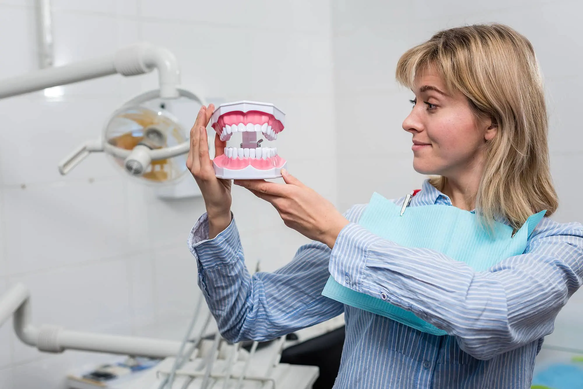 At Happy Smiles Orthodontics in St. Augustine, FL, a dentist smiles as they hold a dental model to explain the Herbst Appliance and its orthodontic benefits to a patient.