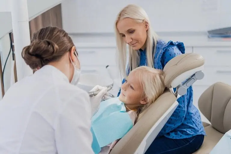 At Happy Smiles Orthodontics, a dentist consults with a young girl and her mother about how to fix overbite in St. Augustine, FL.