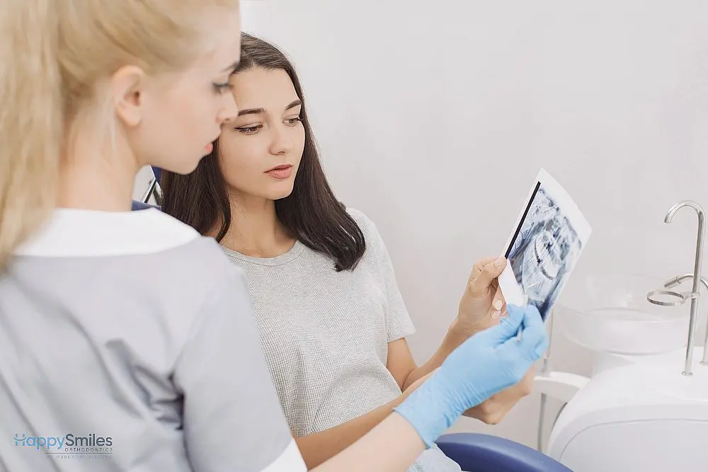 Female dentist showing dental X-rays to a young woman during a consultation explaining about how to fix overbite in St. Augustine, FL.