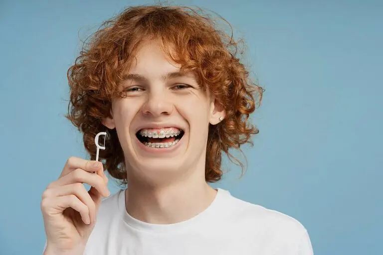 closeup image smiling teenager curly red hair metal braces - How to Floss with Braces in St. Augustine, FL